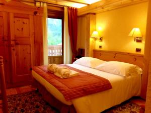 ein Schlafzimmer mit einem Bett, auf dem ein Handtuch liegt in der Unterkunft Eco Wellness Hotel Notre Maison in Cogne