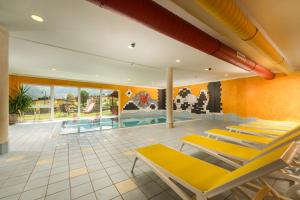 a pool room with lounge chairs and a swimming pool at Apparthotel Bliem in Schladming