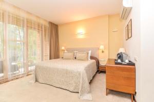 a bedroom with a bed and a tv and a window at Guest House Aštuoni in Palanga +5 photos