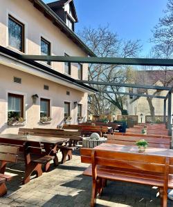 a group of wooden tables and benches outside of a building at Zenntaler Hof in Neuhof an der Zenn