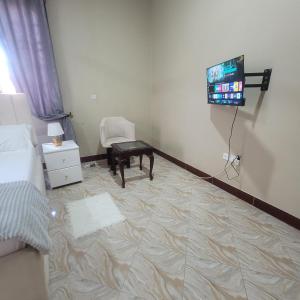 a room with a tv and a chair and a bedroom at Mary homestays in Dar es Salaam