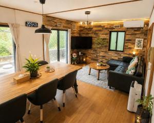 a living room with a couch and a table at 湖畔の詩 BBqが楽しめる隠れ家 琵琶湖徒歩5分 in Takashima