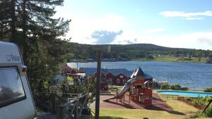 a playground with a slide next to a body of water at Norrfällsvikens Vandrarhem in Mjällom +16 photos