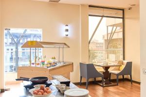a kitchen with a table and some chairs and a counter at La Maison Royale South C in Nairobi