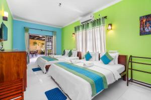 two beds in a room with green walls at The Panorama Negombo in Negombo +45 photos