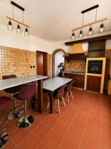 a kitchen with two tables and chairs and a stove at B&B La Vigna dei Fratelli in lido degli scacchi