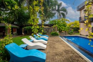 a group of blue and white lounge chairs next to a swimming pool at The Panorama Negombo in Negombo