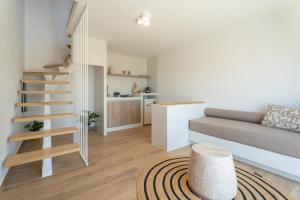 a living room with a staircase and a couch at Serenity Villas in Ios Chora