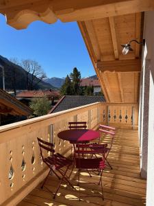 a patio with a table and chairs on a deck at Karls Mittenwald - Design Apartments mit Alpenblick & Tagesbar im Herzen von Mittenwald in Mittenwald +47 photos