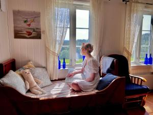 a little girl sitting on a couch next to a window at Landlig leilighet in Landsem
