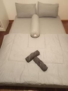 a bed with a white sheet and a bow tie on it at A2 Coconut in Pulau Sarang