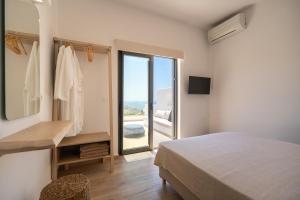 a bedroom with a bed and a view of the ocean at Serenity Villas in Ios Chora +68 photos