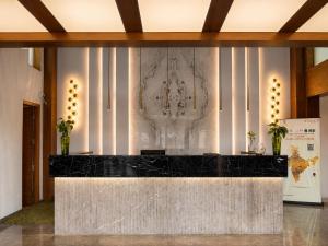 a lobby with a black counter and a marble wall at Quality Inn Gurgaon in Gurgaon +51 photos