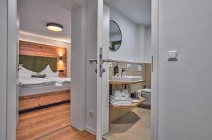 a bathroom with a bed with a sink and a mirror at Annies Bergwelt Haus Waldherz in Bodenmais +41 photos