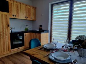 a kitchen with a table with plates and wine glasses at Zielony Zakontek in Ratułów