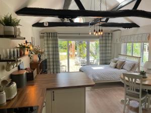 a kitchen and living room with a bed and a table at Lavender Lodge in Briston