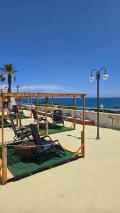 a group of chairs sitting on the beach at Hotel Alba Chiara Sant'Andrea Salento in SantʼAndrea
