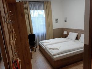 a bedroom with a bed and a window at Víghajós Panzió in Budapest