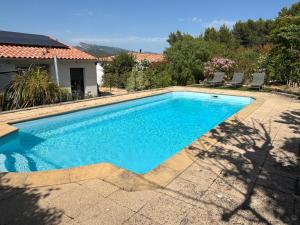 a swimming pool with blue water in a yard at La Maison Bernard in Roquefort-la-Bédoule