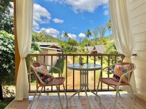 a table and two chairs on a balcony with a view at Chaloklum Beach House in Chaloklum +15 photos