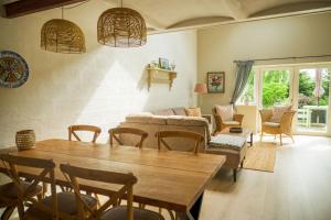 a living room with a table and chairs and a couch at Lustrup Farmhouse in Ribe