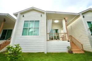 a white house with a porch and a deck at Chaloklum Beach House in Chaloklum