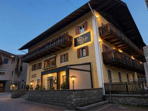 a building with a sign on the side of it at Hotel Hello in Monguelfo