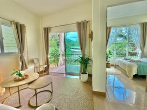 a bedroom with a bed and a view of a balcony at Chaloklum Beach House in Chaloklum