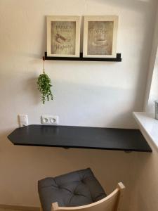 a black shelf on a wall with a chair at Appartement 1 in Wackersdorf