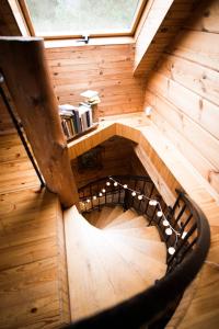 a spiral staircase in a wooden house with a window at Pakaso sodyba in Kirdeikiai