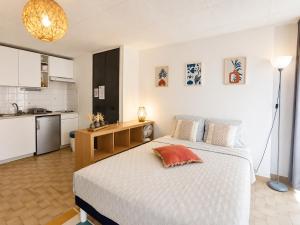 a bedroom with a large bed and a kitchen at Studio spacieux centre-ville avec ascenseur - Le Bohème in Digne-les-Bains