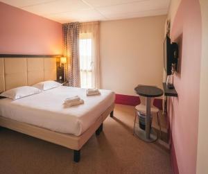 a hotel room with a bed and a table at The Originals City, Hôtel La Verriaire, Cholet Sud in La Verrie