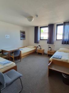 a room with two beds and a table and chairs at RTB-Hotel - Sportschule in Bergisch Gladbach +27 photos