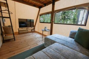 a living room with a couch and a tv at ForRest Glamp Saulkrasti in Saulkrasti