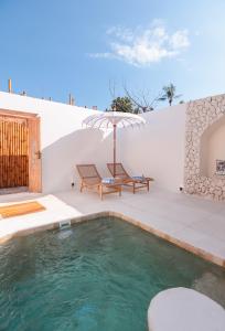 a swimming pool with a bench and an umbrella at The Lost Island- Luxury Private Pool Villas in Gili Trawangan