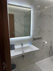 a white bathroom with a sink and a mirror at Hôtel Majestic Rabat Centre in Rabat