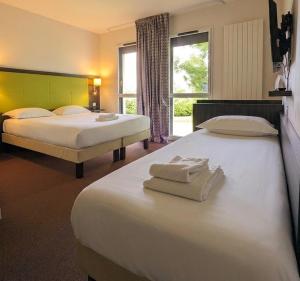 a hotel room with two beds and a window at The Originals City, Hôtel La Verriaire, Cholet Sud in La Verrie +60 photos