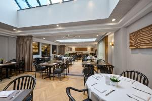 a restaurant with tables and chairs in a room at Keizershof Hotel Aalst in Aalst