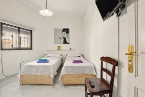 a room with two beds and a chair at Beach 2-bedroom in Los Cristianos in Los Cristianos