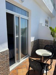 a balcony with a table and chairs and a window at Hôtel Majestic Rabat Centre in Rabat