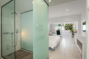 a glass shower in a bedroom with a bed at Dimitra Beach Hotel & Suites in Ágios Fokás +108 photos