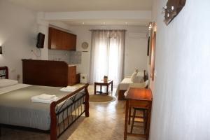 a bedroom with a bed and a desk in a room at Mahi Studios in Patitiri