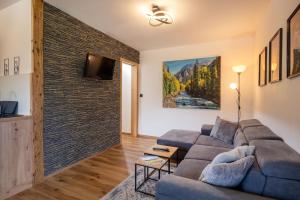 a living room with a couch and a brick wall at Ferienwohnung Tommarlhof in Söll