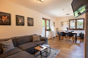 a living room with a couch and a dining room at Ferienwohnung Tommarlhof in Söll