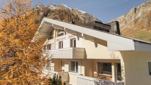 a hotel building with a mountain in the background at Atlantis Apartments by MEIN SAMNAUN - MOUNTAIN HOMES in Samnaun