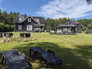 a house with two lawn chairs in a yard at GREY PINE HOUSE in Druskininkai