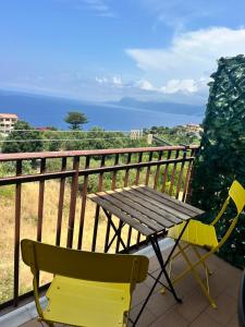 a wooden table and chairs on a balcony with the ocean at Casa Vacanze Scilla in Scilla +9 photos