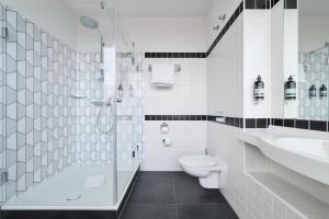 a bathroom with a toilet and a sink and a shower at Premier Inn München City Ost in Munich +18 photos