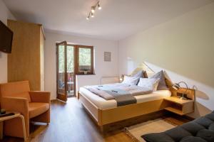 a bedroom with a bed and a chair at Ferienwohnung Tommarlhof in Söll