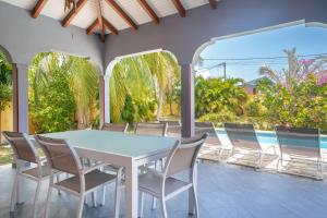 a table and chairs on a patio with a pool at Villa Aquarium in Saint-François